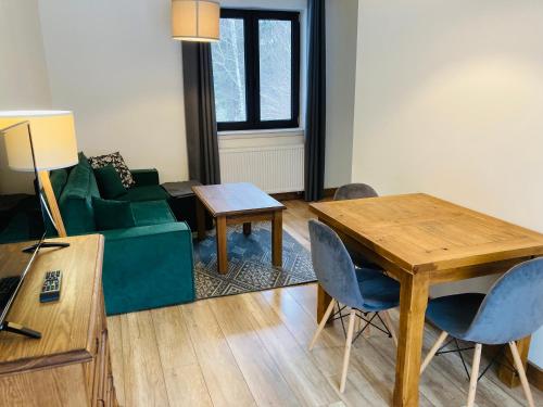 a living room with a green couch and a table at Modryna - Modrzewiowy Dom in Cisna