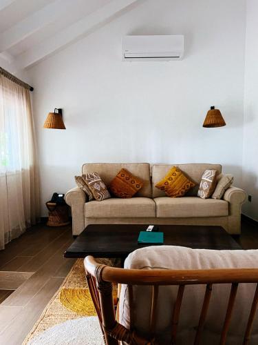 a living room with a couch with pillows on it at Bom Bom - Principe Collection in Principe