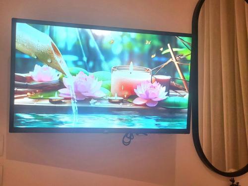a television screen with a picture of a candle and flowers at Madinity B8 - Fantasy Studio in Madinaty