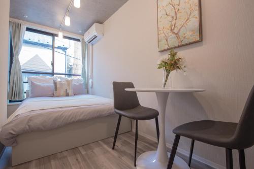 a small bedroom with a bed and a table and chairs at 東上野の隠れ家 上野駅徒歩圏内のアットホームな宿 EoE6 SioE in Tokyo