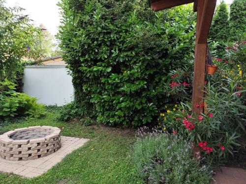 a garden with a stone fire pit in front of a bush at Sunshine Villa Fonyódliget in Fonyód