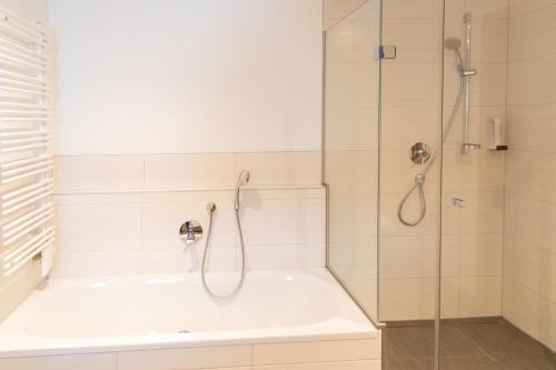 a bathroom with a shower and a bath tub at Appartements Kirchenwirt in Kirchberg in Tirol