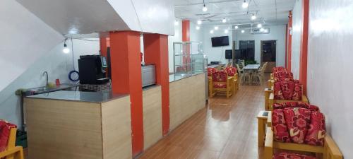 a room with a bar with red columns and chairs at SID'S Traveller's INN in General Santos