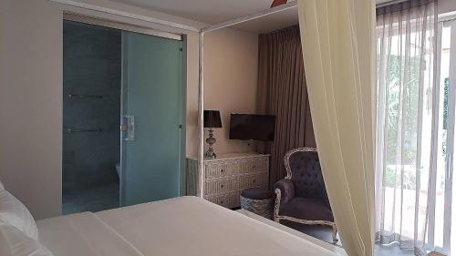 a bedroom with a bed and a tv and a window at O - HO Boutique Home in Baan Tai