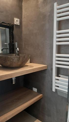 La salle de bains est pourvue d'un lavabo et d'un miroir sur une étagère. dans l'établissement La casa dell arte Arles centre, à Arles