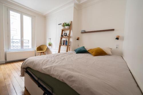 une chambre avec un grand lit et une fenêtre dans l'établissement Appartement cosy à Montmartre, à Paris