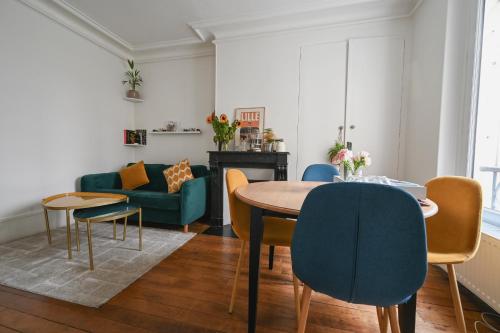 un salon avec une table, des chaises et un canapé dans l'établissement Appartement cosy à Montmartre, à Paris