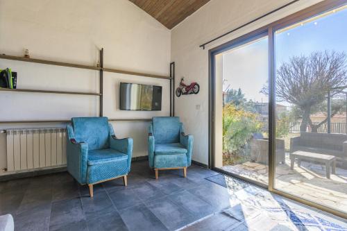 two blue chairs in a room with a window at Villagio Resort in Zaarour in Zaarour