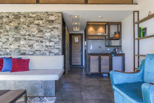 a living room with a couch and a stone wall at Villagio Resort in Zaarour in Zaarour