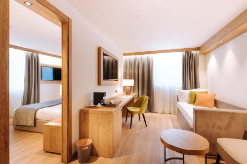a hotel room with a bed and a desk at Valtur Cervinia Cristallo Ski Resort in Breuil-Cervinia
