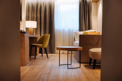 a hotel room with a table and a couch at Valtur Cervinia Cristallo Ski Resort in Breuil-Cervinia