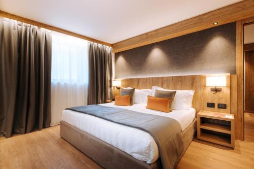 a hotel room with a large bed and a window at Valtur Cervinia Cristallo Ski Resort in Breuil-Cervinia