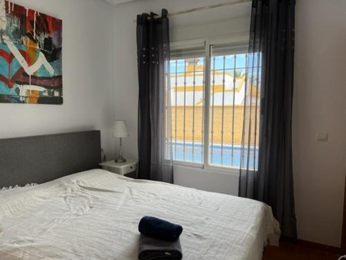 マサロンにあるVilla Caprichoのベッドルーム1室(ベッド1台付)、窓(プール付)