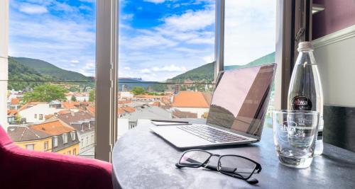 a laptop sitting on a table next to a window at PLAZA Premium Heidelberg in Heidelberg