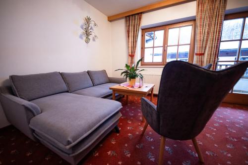 a living room with a couch and a table at Dandler - Zimmer und Ferienwohnungen in Fieberbrunn