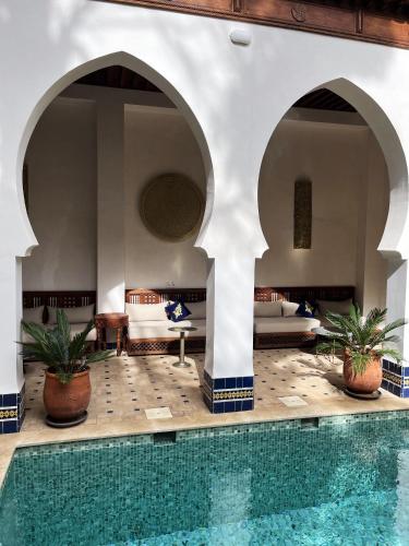 a hotel lobby with a swimming pool and a bedroom at Riad Hanael Garden & Spa in Fès
