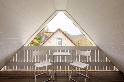 a attic room with three chairs and a window at Villa Johanna in Bad Herrenalb