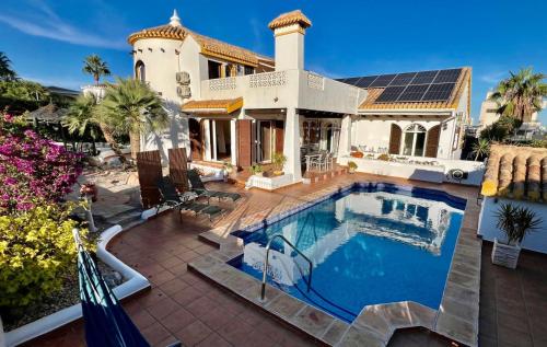 a house with a swimming pool in front of a house at Ibiza style villa first line to golf! in Villamartin