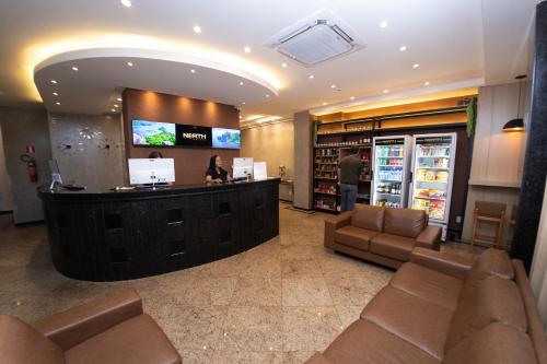a lobby of a store with a woman at a counter at NORTH HOTEIS in Montes Claros