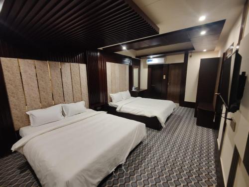 a hotel room with two beds and a tv at Hotel Istanbul & Spa in Sylhet