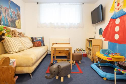 a living room with a couch and many toys at Aktiv Panoramahotel Daniel in Sautens