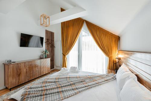 a bedroom with a large bed and a large window at Elviu Guesthouse in Lacu Rosu