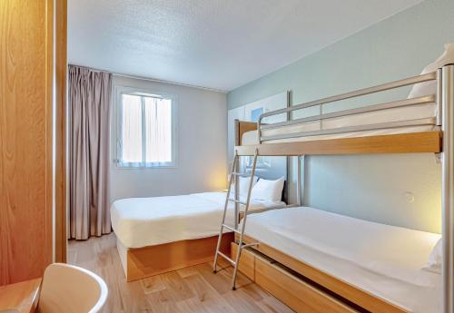 a small room with two bunk beds and a desk at B&B HOTEL Brignoles in Brignoles