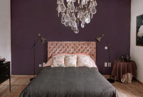 a bedroom with a large bed and a chandelier at Les Wespellières 1897 - En vis à vis de Pairi Daiza in Brugelette