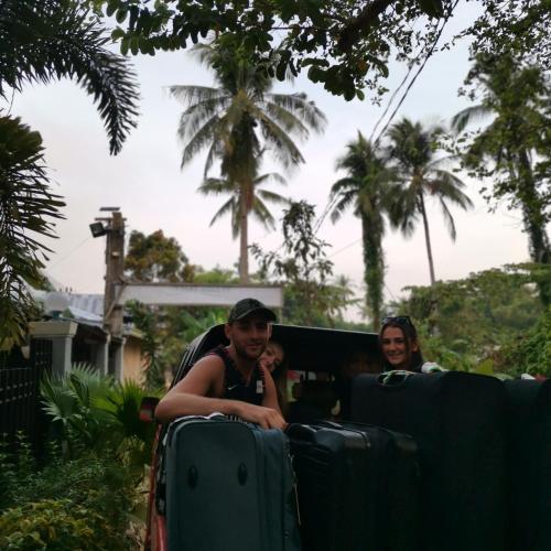 two people riding in a train with luggage at Layang Layang Home in El Nido