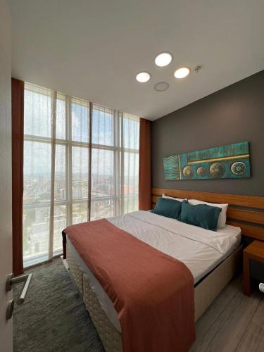 a bedroom with a large bed with a large window at ZİN D Home Dudullu Suit Otel in Istanbul