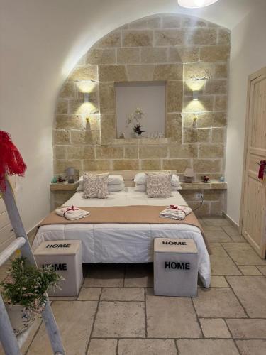 a bedroom with a bed and a stone wall at Casetta dello Scrittore in Ostuni
