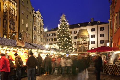 a crowd of people at a christmas market with a christmas tree at Kaiser Max Design Appartements in Innsbruck