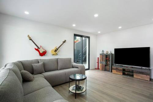 a living room with a couch and a flat screen tv at Villa Angela in Funchal