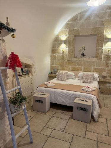 a bedroom with a bed in a stone wall at Casetta dello Scrittore in Ostuni