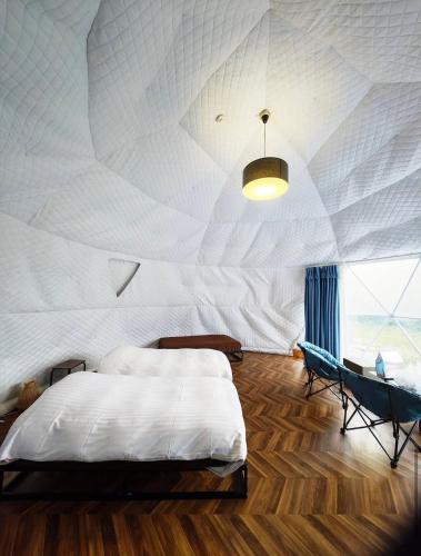 a bedroom with a large bed and a table at Ｋ&Ｂグランピング　天空の城 in Takeda
