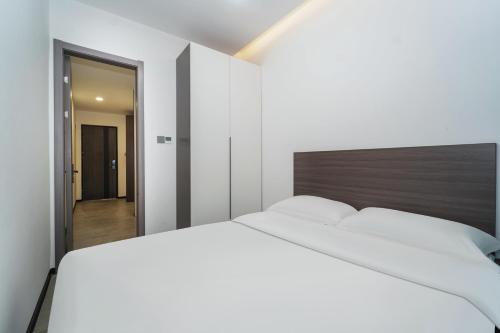 a bedroom with a large white bed and a hallway at Banyueli Hotel in Shanghai