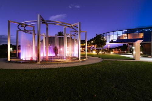a fountain in front of a building at night at Hotel Vivat in Moravske Toplice