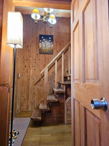a hallway with wooden walls and stairs in a house at Pet friendly NASU Royal Villa ペットと泊まれる広々貸切別荘 那須ロイヤルヴィラBBQ駐車5台OK in Nasu