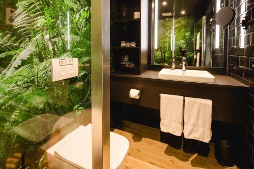 a bathroom with a sink and a plant at Rioca Frankfurt Posto 7 in Frankfurt