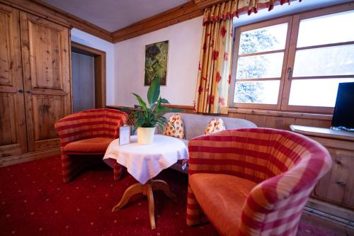 a living room with two chairs and a table at Dandler - Zimmer und Ferienwohnungen in Fieberbrunn
