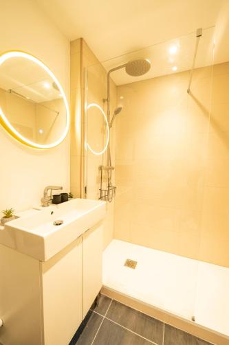 une salle de bain blanche avec un lavabo et une douche dans l'établissement Nancy Cure Thermale - ARTEM - Parc Sainte Marie - 1er ORANGE, à Nancy