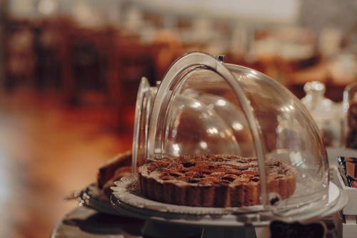 a cake in a glass dome on a table at Locanda La Brenva - Estella Hotel Collection & Experience in Courmayeur