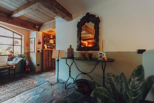 a room with a table and a mirror on the wall at Locanda La Brenva - Estella Hotel Collection & Experience in Courmayeur