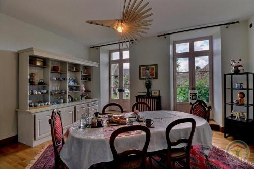 a dining room with a table and some chairs at O jardin sakura in Les Portes du Coglais