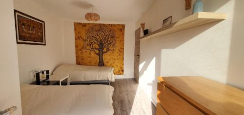 - une chambre avec une fresque murale sur les arbres dans l'établissement Appartement 3 pièces Strasbourg - Mundolsheim, à Mundolsheim