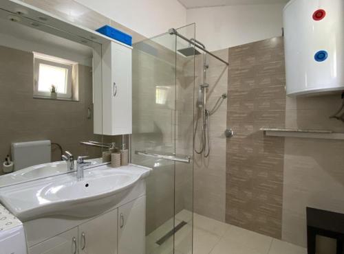 a bathroom with a sink and a shower at Luxury Lovran Apartments with Swimming Pool in Lovran