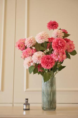 a vase filled with pink flowers sitting on a table at Hawa House Phuket in Phuket Town