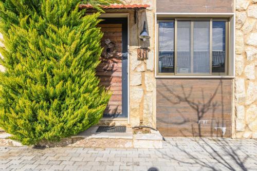 a house with a pine tree next to a door at Villagio Resort in Zaarour in Zaarour