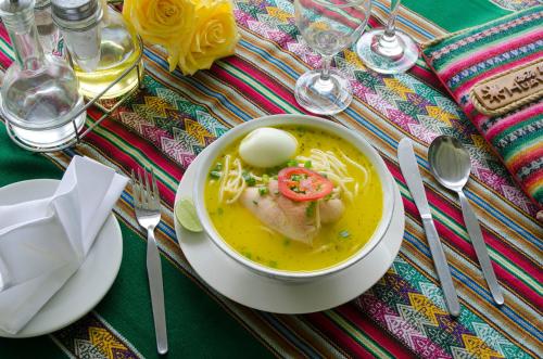 a bowl of soup with an egg on a table at Centro Vacacional Huaychulo in Concepción