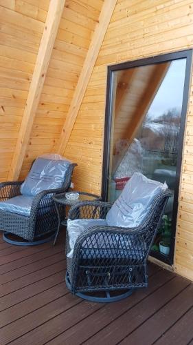 two wicker chairs and a table on a deck at CABANA 365 in Braşov